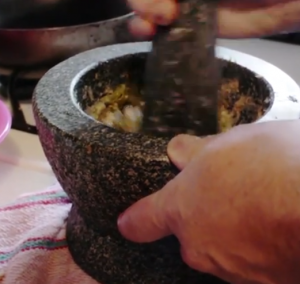 Ricker pounding out some nam prik num with his mortar and pestle (screenshot from Farang) 