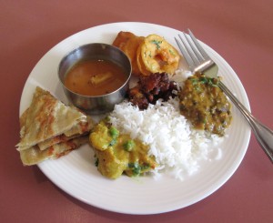 clockwise: mixed pekora, dal makani, white rice, vegetable korma, paratha, sambar, & vegetable manchunn