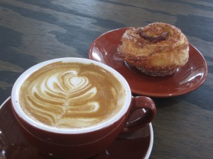 a flat white with a cinnamon roll by Frenchies  